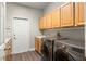 Laundry room equipped with modern washer and dryer, countertop, sink and wooden cabinetry at 6020 Kestrel Point Ave, Lithia, FL 33547