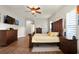 A lovely main bedroom features gorgeous dark wood floors, furniture, and a ceiling fan at 6020 Kestrel Point Ave, Lithia, FL 33547