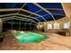 Illuminated screened-in pool and spa with stone pavers and outdoor lighting at 6020 Kestrel Point Ave, Lithia, FL 33547