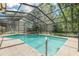 Sparkling screened-in pool with tiled edge, hot tub and wooded backdrop at 823 Scenic Heights Dr, Brandon, FL 33511