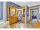 Luxurious bathroom featuring a vanity with Hollywood lighting, cabinetry, and tile floors at 8755 Commodore Dr, Seminole, FL 33776
