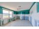 Bedroom with aqua accent walls, ready for remodel, and a large window showcasing the exterior at 9439 Sun Isle Ne Dr, St Petersburg, FL 33702