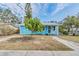 Beautifully renovated light blue home with white trim, lush landscaping, and inviting entrance at 1841 Overbrook Ave, Clearwater, FL 33755