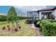 Landscaped backyard with a screened patio, mature trees, and a well-maintained lawn at 19367 Coastal Shore Ter, Land O Lakes, FL 34638