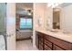 Bathroom featuring a double vanity with a view of the primary bedroom at 19367 Coastal Shore Ter, Land O Lakes, FL 34638