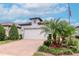 Charming home featuring a brick driveway, manicured lawn, and a two-car garage at 19367 Coastal Shore Ter, Land O Lakes, FL 34638