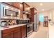 Modern kitchen featuring stainless steel appliances and dark wood cabinetry at 19367 Coastal Shore Ter, Land O Lakes, FL 34638