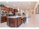 Bright, open kitchen with a large center island, stainless appliances, and dark cabinets at 19367 Coastal Shore Ter, Land O Lakes, FL 34638