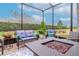 Inviting screened patio featuring comfortable seating and a modern fire pit, perfect for outdoor relaxation at 19367 Coastal Shore Ter, Land O Lakes, FL 34638