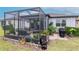 View of screened patio with outdoor seating, landscaping, and a barbecue grill, perfect for outdoor living at 19367 Coastal Shore Ter, Land O Lakes, FL 34638