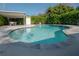 Large kidney-shaped pool featuring a tiled border, lounge chairs, and a covered patio in the backyard at 3611 W De Leon St, Tampa, FL 33609
