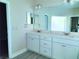 Bathroom featuring double sinks with granite countertops and gray wood-look tile flooring at 422 Shannon Estates Ct, Plant City, FL 33563