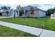 A wide view of a single-story home featuring a brick facade, manicured lawn, and a long driveway at 422 Shannon Estates Ct, Plant City, FL 33563