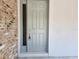 A gray front door featuring a brick exterior and glass pane welcomes you home at 422 Shannon Estates Ct, Plant City, FL 33563