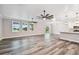 Bright living room with wood-look floors, ceiling fans, and natural light coming from large windows and sliding doors at 422 Shannon Estates Ct, Plant City, FL 33563
