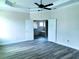 Main bedroom featuring an ensuite bathroom with double doors and wood-look flooring at 422 Shannon Estates Ct, Plant City, FL 33563