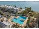 Aerial view of a community pool surrounded by palm trees and lounge chairs with ocean views at 5940 30Th S Ave # 209, Gulfport, FL 33707