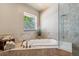 Bright bathroom featuring a soaking tub, glass-enclosed shower, and natural light at 6423 Driftwood Dr, Hudson, FL 34667