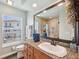 Bathroom featuring a large mirror, wood cabinets, and a view of a neighboring home at 6423 Driftwood Dr, Hudson, FL 34667
