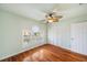 Bedroom with wood floors, ceiling fan, plantation shutters, closet, and door at 6423 Driftwood Dr, Hudson, FL 34667