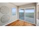 Bright bedroom featuring hardwood floors, balcony access, and modern decorative wall art at 6423 Driftwood Dr, Hudson, FL 34667