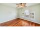 Bright bedroom features wood floors, a ceiling fan, and a window with plantation shutters at 6423 Driftwood Dr, Hudson, FL 34667