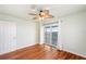 Bright bedroom featuring hardwood floors, ceiling fan, and sliding door access to a balcony at 6423 Driftwood Dr, Hudson, FL 34667