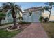 Beautiful home featuring brick paver driveway, lush landscaping, and a two-car garage at 6423 Driftwood Dr, Hudson, FL 34667