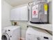 Laundry room featuring side-by-side washer and dryer and storage cabinets at 6423 Driftwood Dr, Hudson, FL 34667