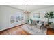 Cozy living room featuring plantation shutters, a decorative chandelier, and hardwood floors at 6423 Driftwood Dr, Hudson, FL 34667