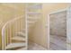 View of spiral staircase leading to doorway and another room with cinderblock walls at 6423 Driftwood Dr, Hudson, FL 34667