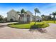 Stately home featuring a circular driveway, towering columns, well-manicured lawn, and lush palm trees at 11518 Hammock Oaks Ct, Lithia, FL 33547