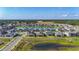 Aerial view features a serene lake bordered by modern homes, with verdant landscaping and clear blue skies at 13028 Homestead Ln, Parrish, FL 34219