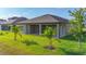 Well-maintained backyard with a covered patio that enhances outdoor enjoyment, and is landscaped with young palm trees at 13028 Homestead Ln, Parrish, FL 34219