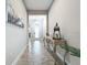 Spacious entryway featuring wood-look tile flooring, an ornate console table, and a decorative front door at 13028 Homestead Ln, Parrish, FL 34219