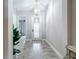 Elegant entryway with wood-look tile flooring, a stylish chandelier, and a glimpse of a cozy bedroom at 13028 Homestead Ln, Parrish, FL 34219
