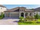 Charming single-story home with a brick driveway, neutral stucco, three-car garage and beautiful landscaping at 13028 Homestead Ln, Parrish, FL 34219