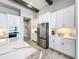 Well-equipped kitchen with stainless steel appliances, white cabinets, marble countertops, and wood-look tile flooring at 13028 Homestead Ln, Parrish, FL 34219