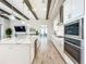 Modern kitchen featuring a large island with marble countertops, stainless steel appliances, and wood-look tile floors at 13028 Homestead Ln, Parrish, FL 34219