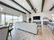 Open-concept living area with a large sectional sofa, wood-look tile flooring, and lots of natural light at 13028 Homestead Ln, Parrish, FL 34219