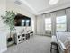 Light-filled bedroom with tray ceiling, entertainment center, and large windows at 13028 Homestead Ln, Parrish, FL 34219