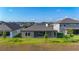 The rear exterior shows a covered patio, green grass, and a neutral paint scheme at 13028 Homestead Ln, Parrish, FL 34219
