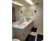 Bright bathroom with double sinks and ample countertop space, decorative wall art and patterned floor at 255 Capri N Cir # 17, Treasure Island, FL 33706