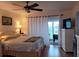 Comfortable bedroom with a ceiling fan and sliding glass doors to the outside balcony at 255 Capri N Cir # 17, Treasure Island, FL 33706