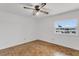 Bright bedroom features a ceiling fan and light, parquet floors, and a window view to the outside at 4902 Stolls Ave, Tampa, FL 33615