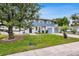 Charming two-story home with a well-maintained lawn, beautiful landscaping, and light blue painted accents at 4902 Stolls Ave, Tampa, FL 33615