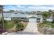Charming home features a well-manicured front yard, lush landscaping, and waterfront views at 7800 3Rd S Ave, St Petersburg, FL 33707