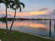 Picturesque water view at sunset featuring palm trees, a tranquil bay, and vibrant skies at 7800 3Rd S Ave, St Petersburg, FL 33707