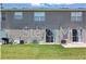 A view of the back of the home with sliding glass doors leading to a green grassy yard at 8856 Christie Dr # 0, Largo, FL 33771
