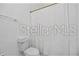 Neat bathroom featuring a toilet and shower with white tiles and hardware at 8856 Christie Dr # 0, Largo, FL 33771